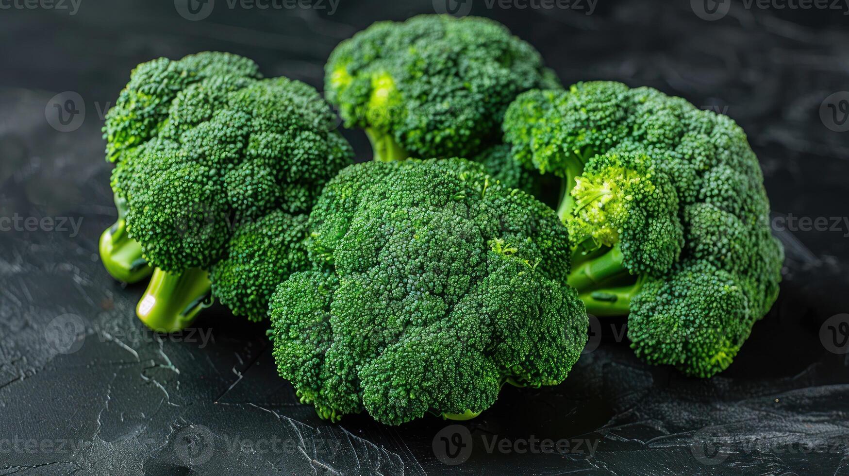 A bunch of fresh broccoli is placed on top of a wooden table photo