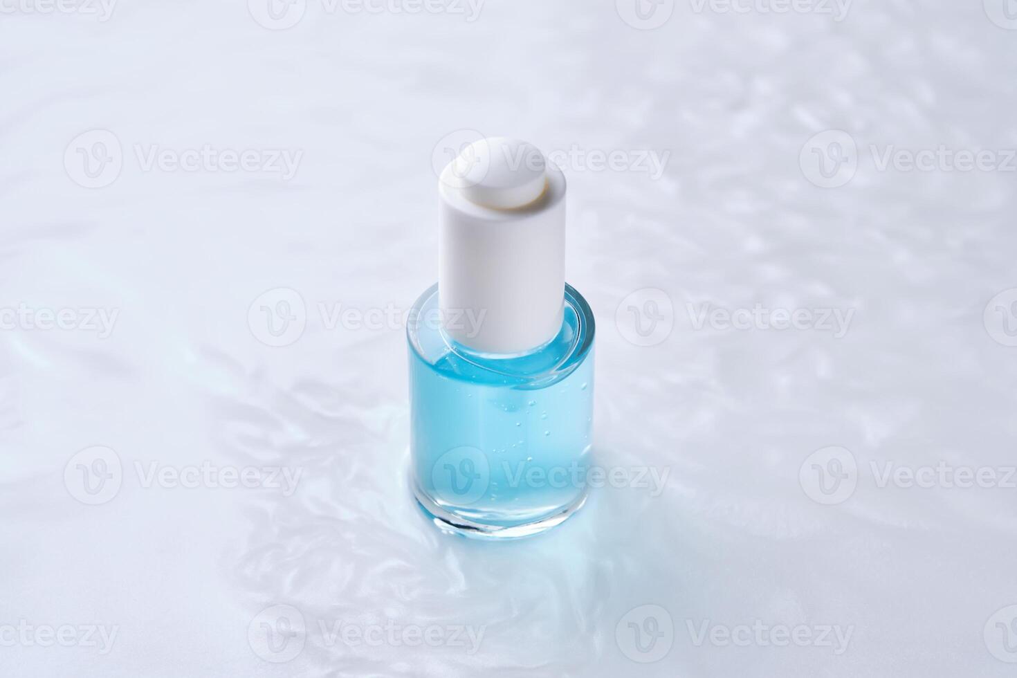 Bottles of serum with a dropper in liquid with pearl tints. photo