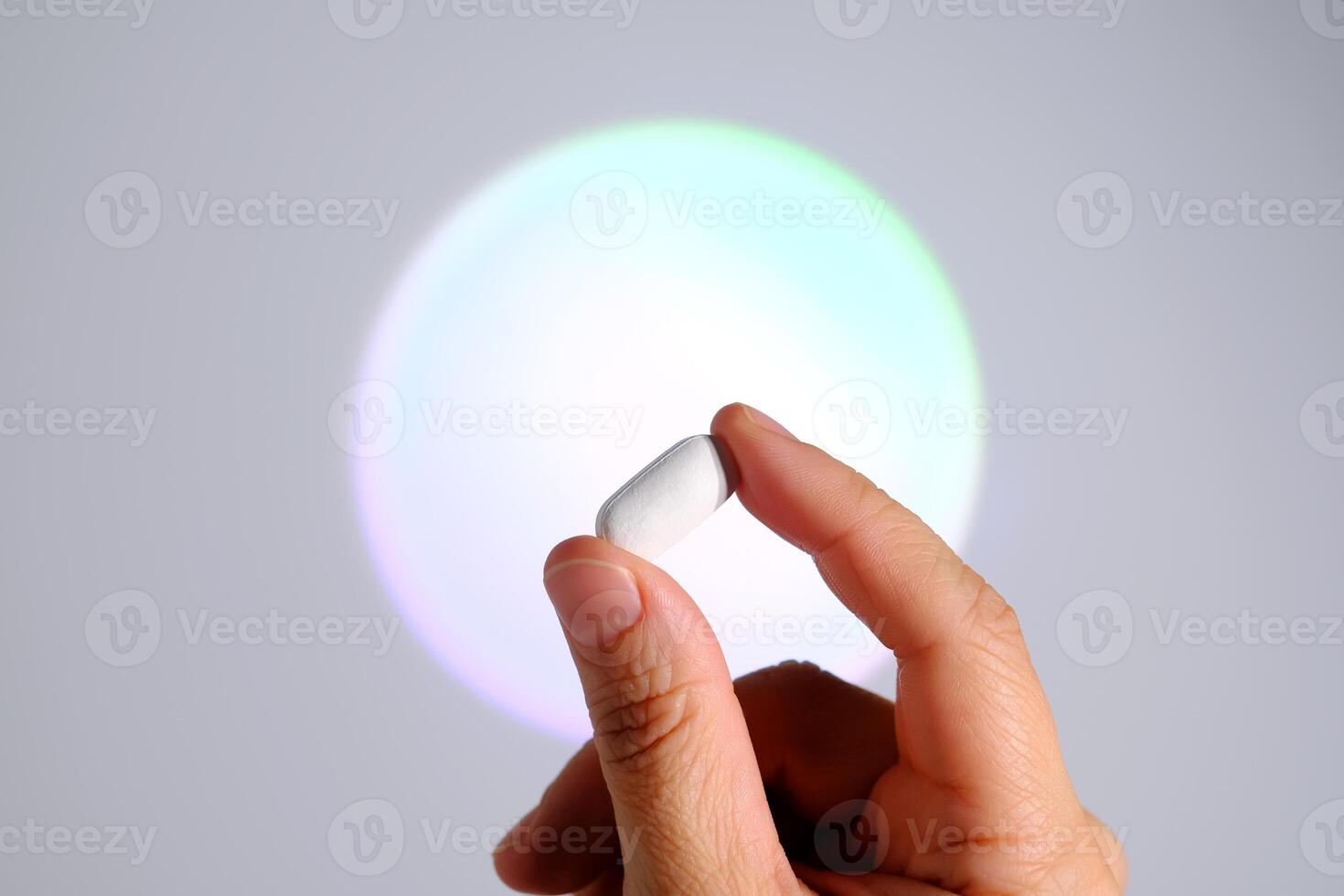Tablet in hand against the background of a glowing circle. photo