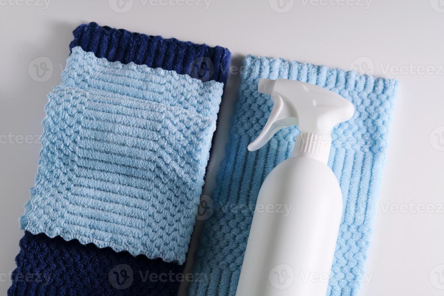 Cleaning product with a sprayer on a background of a blue microfiber cloth. photo