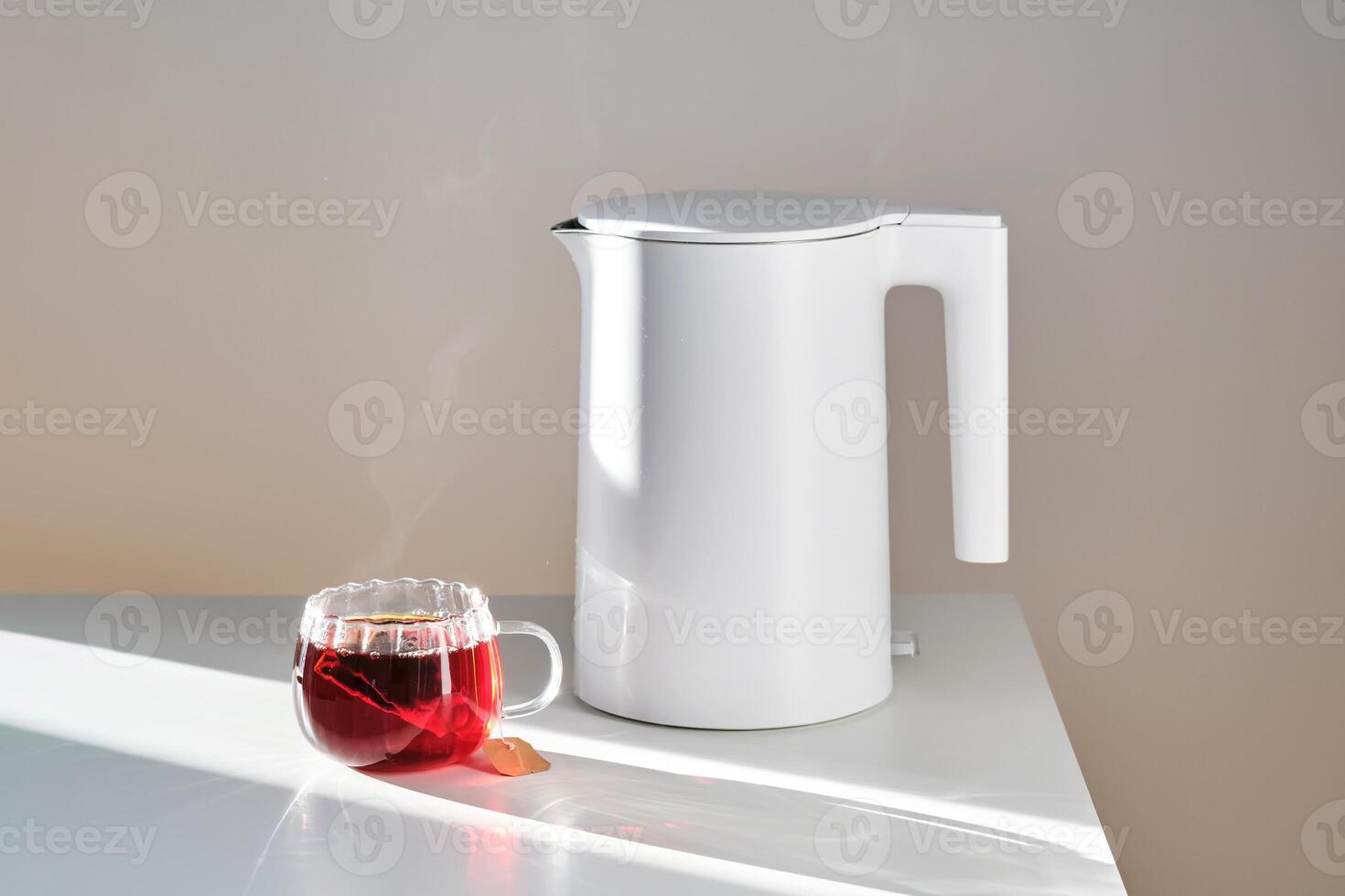 Glass mug with hot black tea on the table. photo