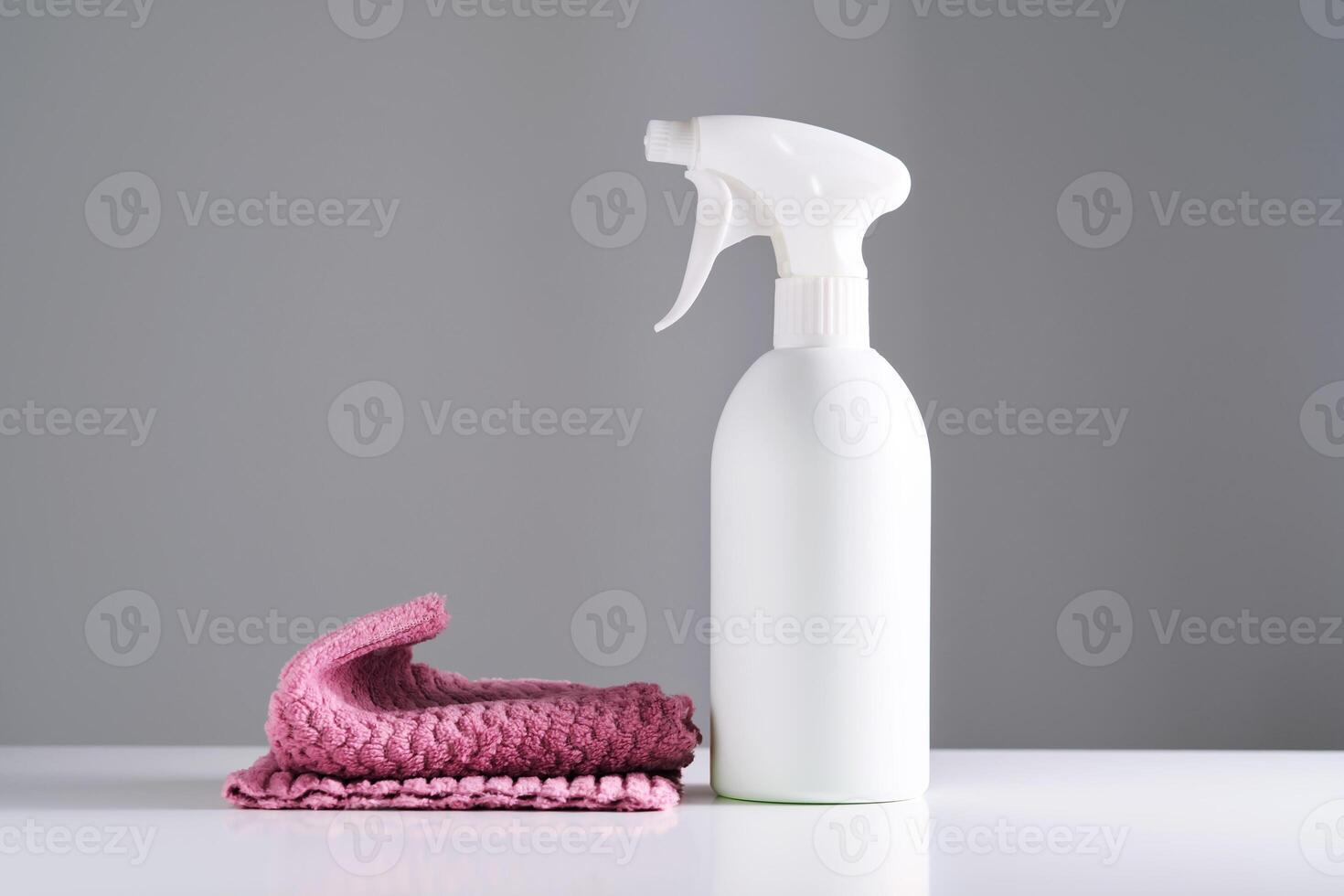 Cleaning product with a sprayer on a background of a red microfiber cloth. photo
