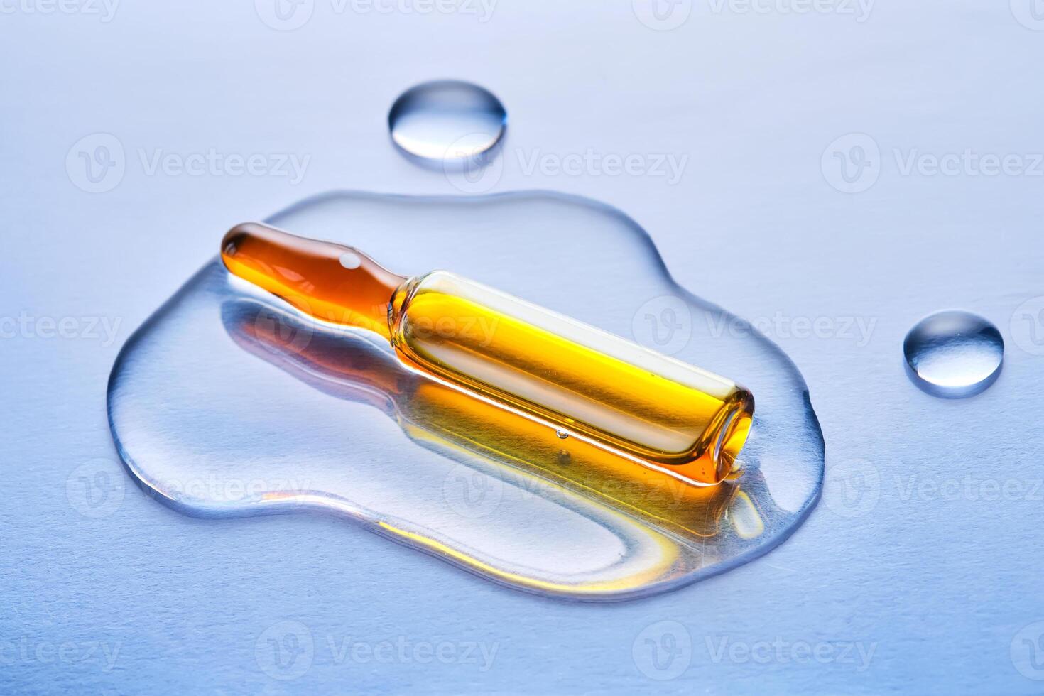 Ampoules in liquid on a blue background. photo
