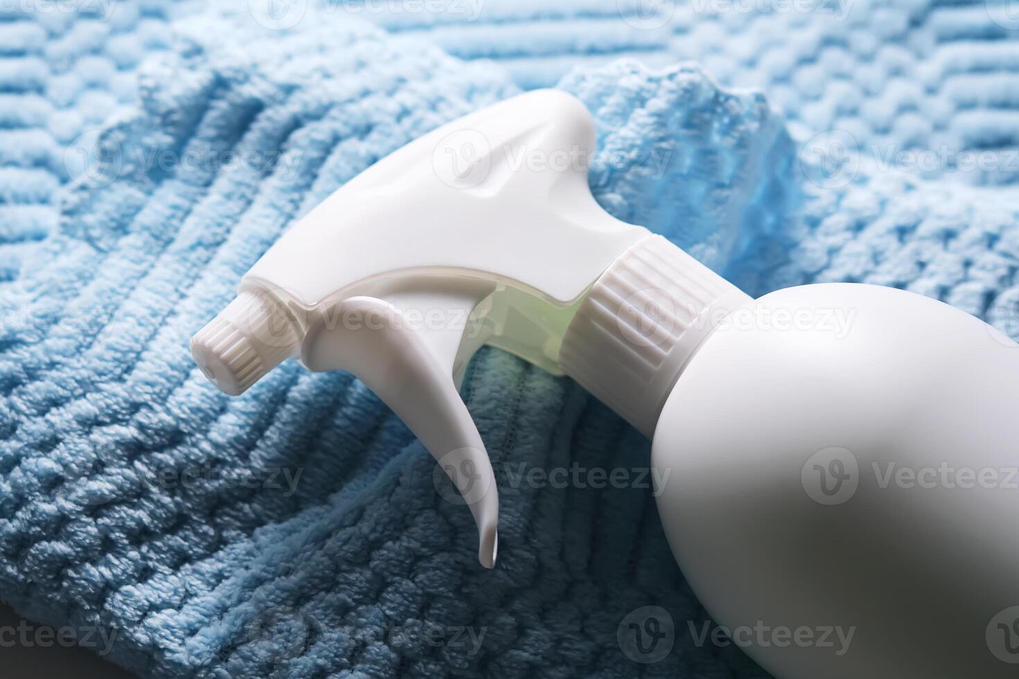 Cleaning product with a sprayer on a background of a blue microfiber cloth. photo