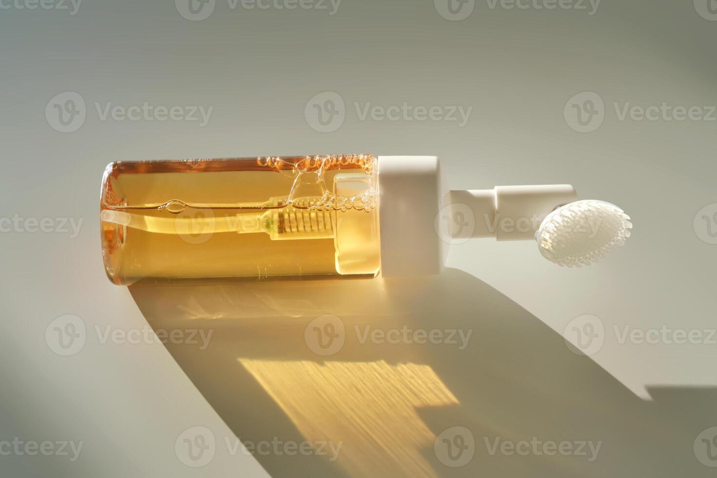 Beige facial foam with a dispenser and brush in the rays of the setting sun. photo
