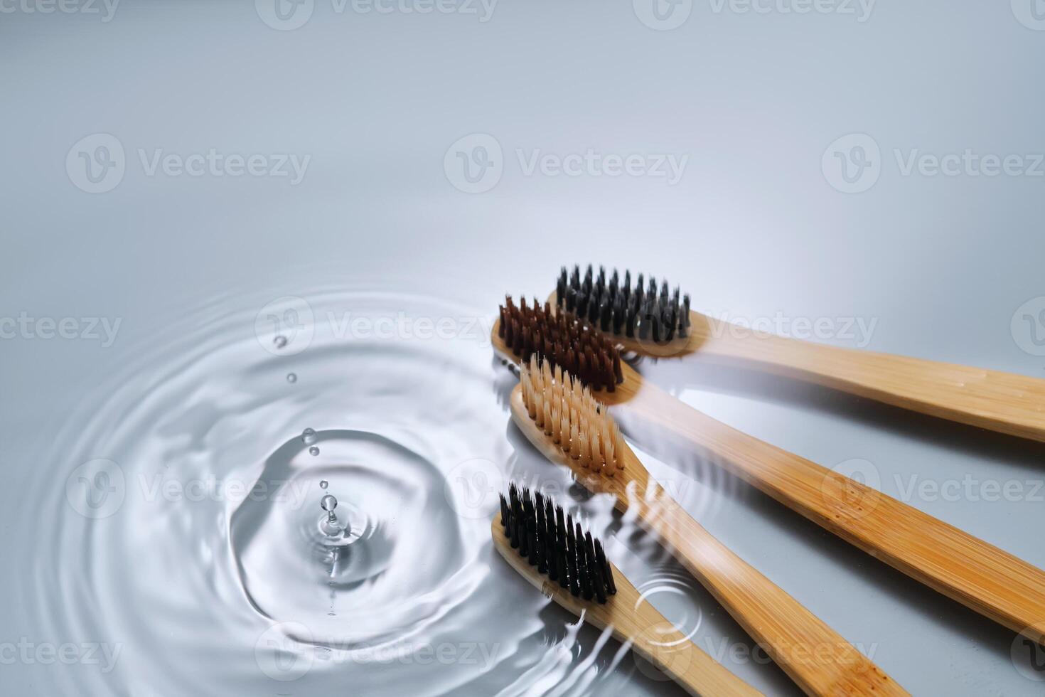 Natural bamboo toothbrushes in water on a blue background. photo