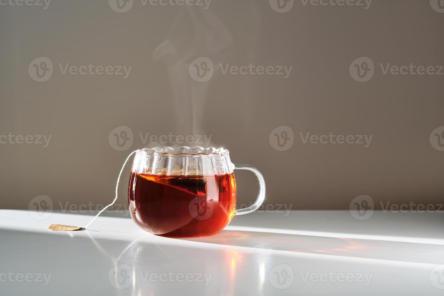 Glass mug with hot black tea on the table. photo