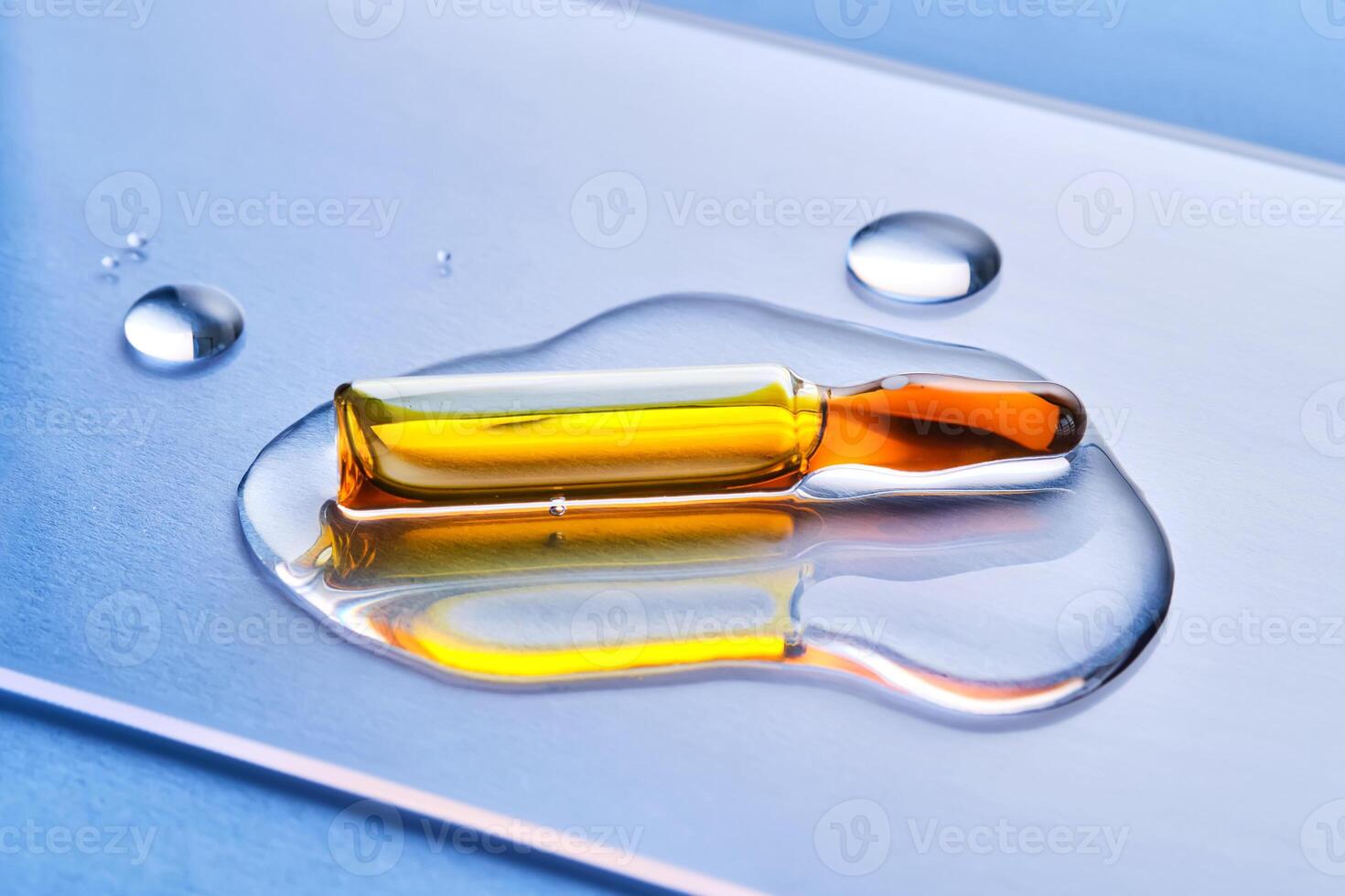 Ampoules in liquid on a blue background. photo