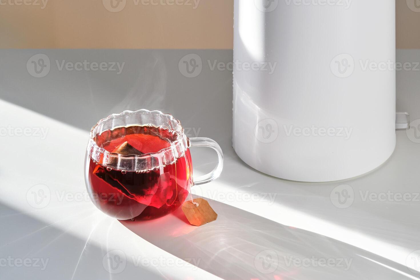 Glass mug with hot black tea on the table. photo