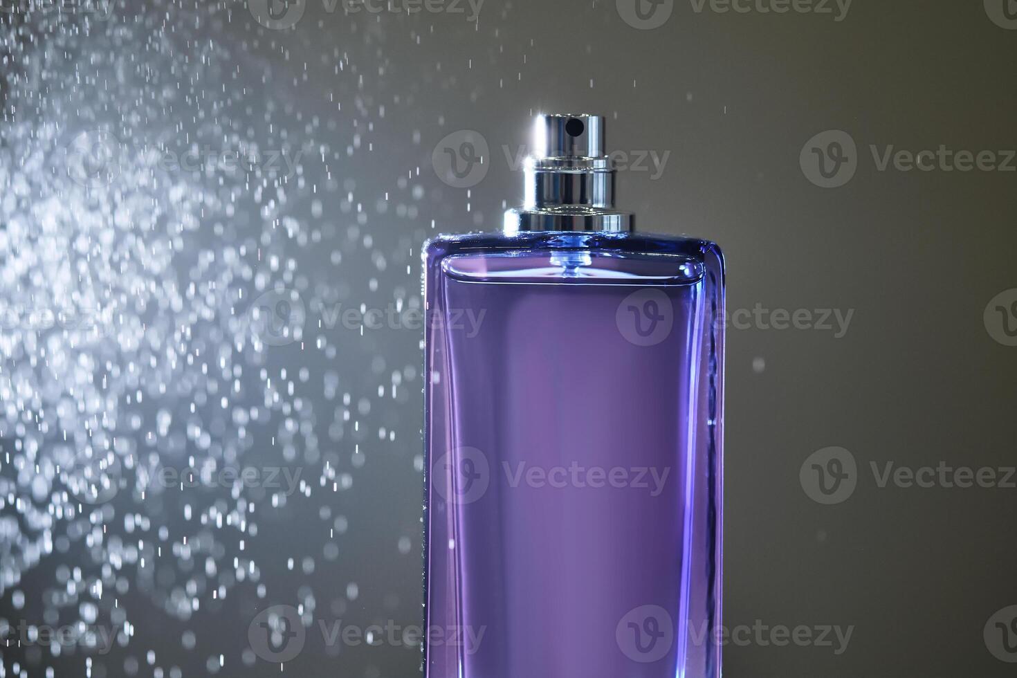 perfume rociar en un Violeta botella en un oscuro antecedentes. foto