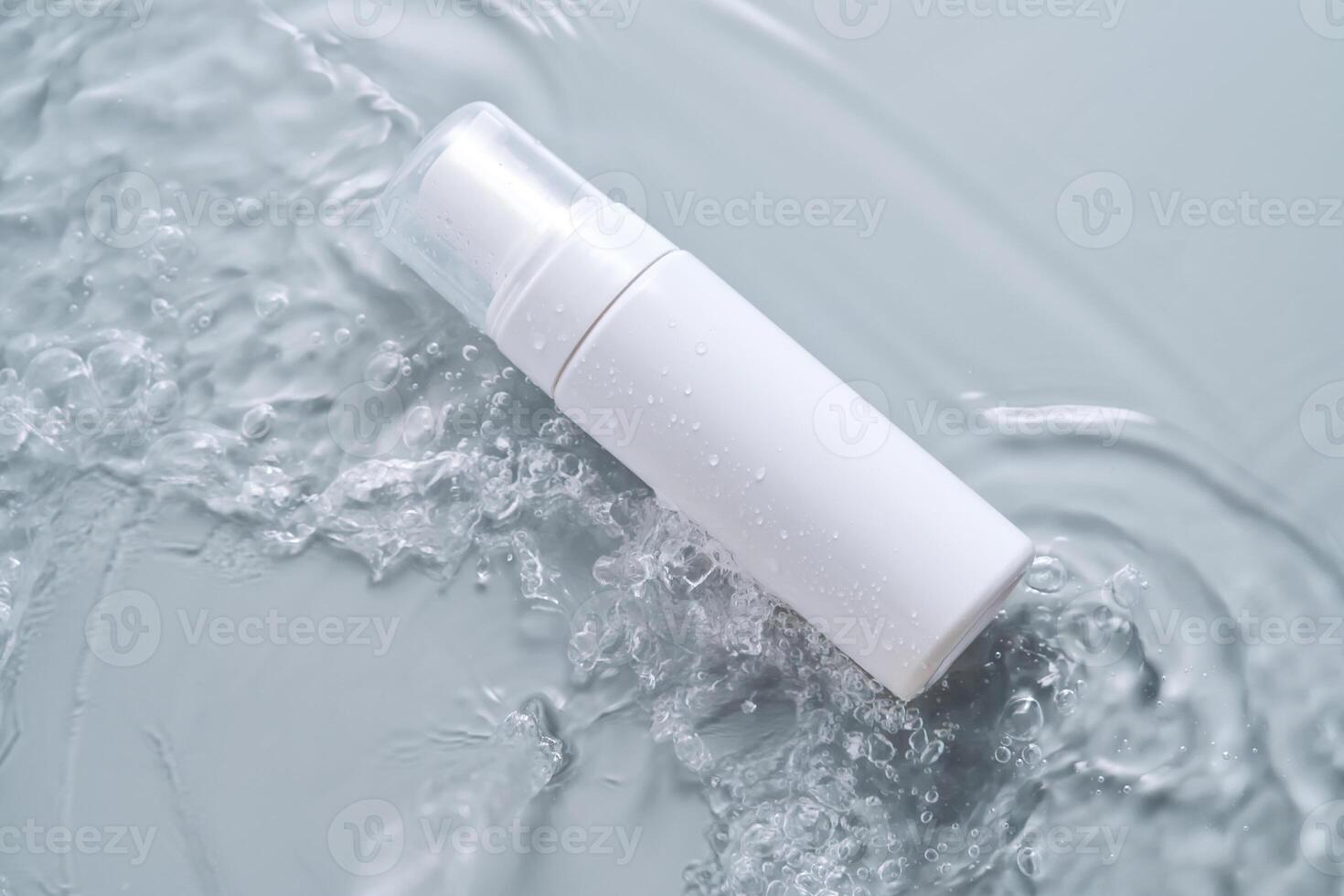 Bottles of cosmetic products in water on a blue background. photo