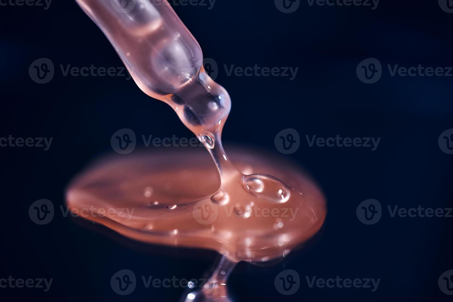 Bottle with pink serum on a blue background. photo