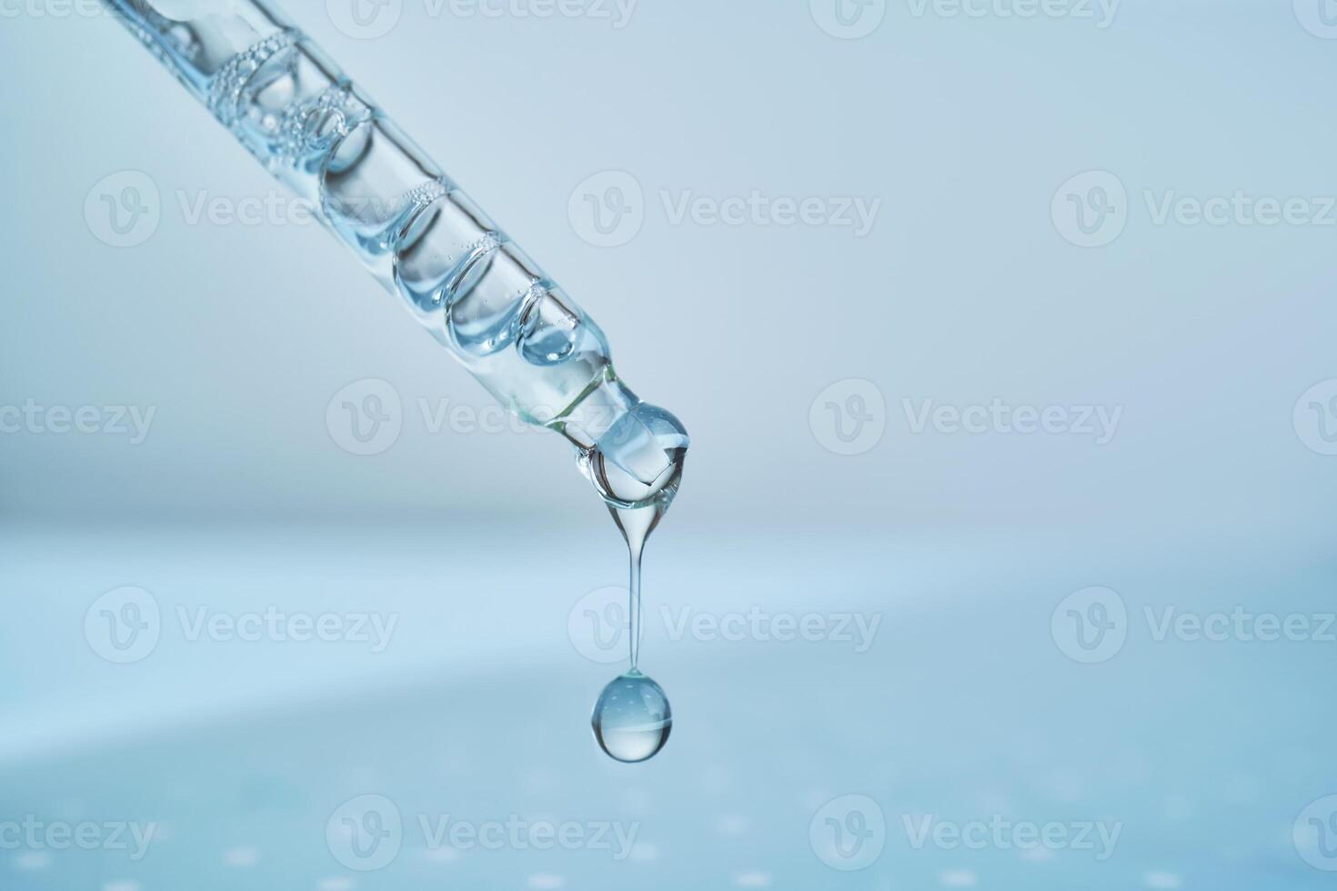 Pipette with serum on a blue background. photo