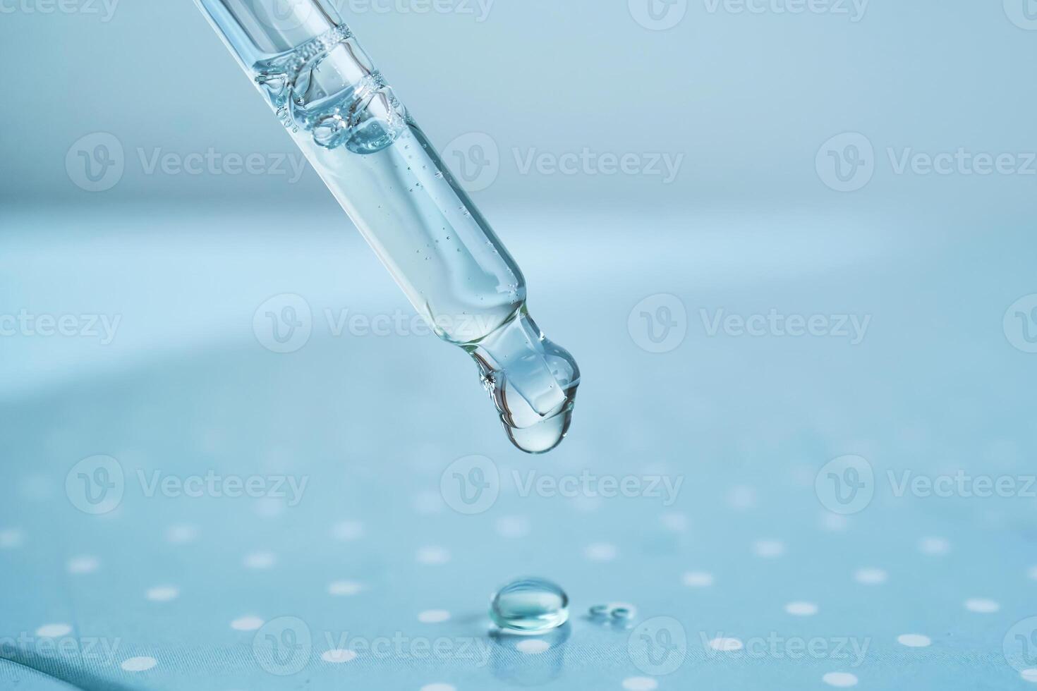 Pipette with serum on a blue background. photo