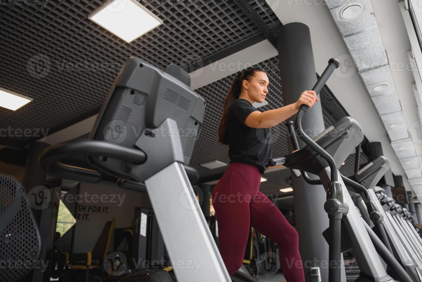 attractive young woman runs on a treadmill, is engaged in fitness sport club. photo