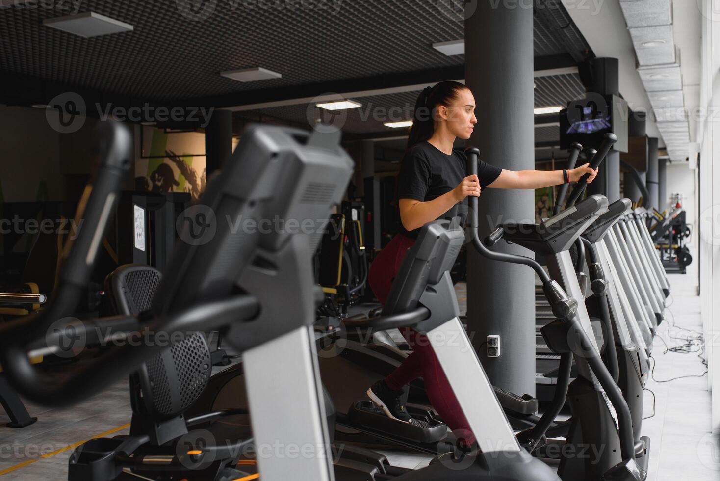 attractive young woman runs on a treadmill, is engaged in fitness sport club. photo