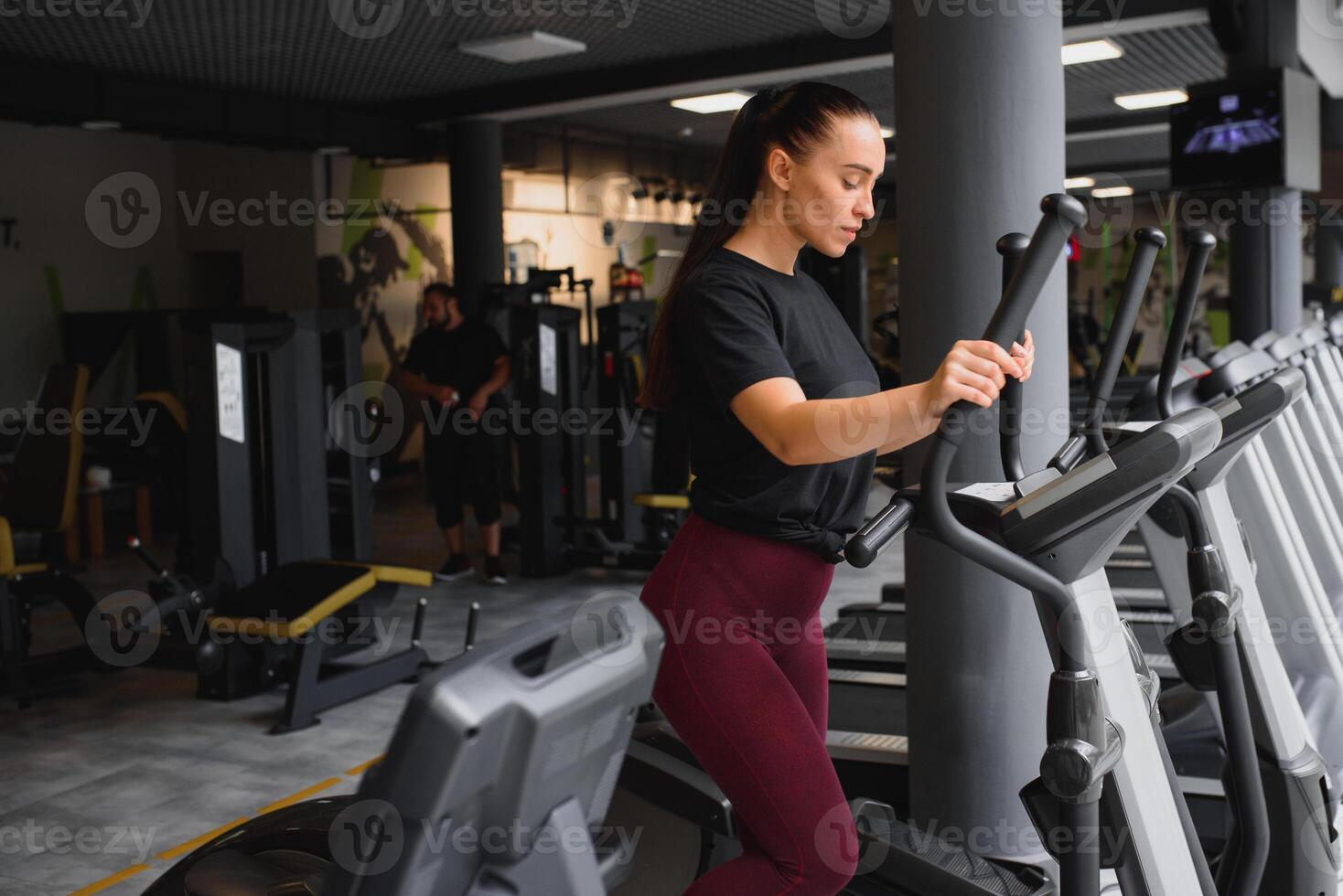 attractive young woman runs on a treadmill, is engaged in fitness sport club. photo