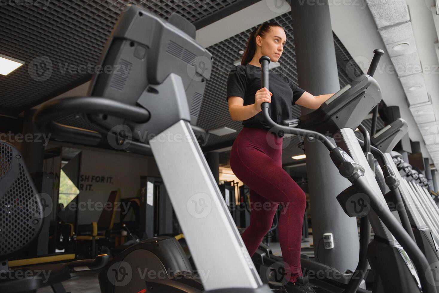 attractive young woman runs on a treadmill, is engaged in fitness sport club. photo