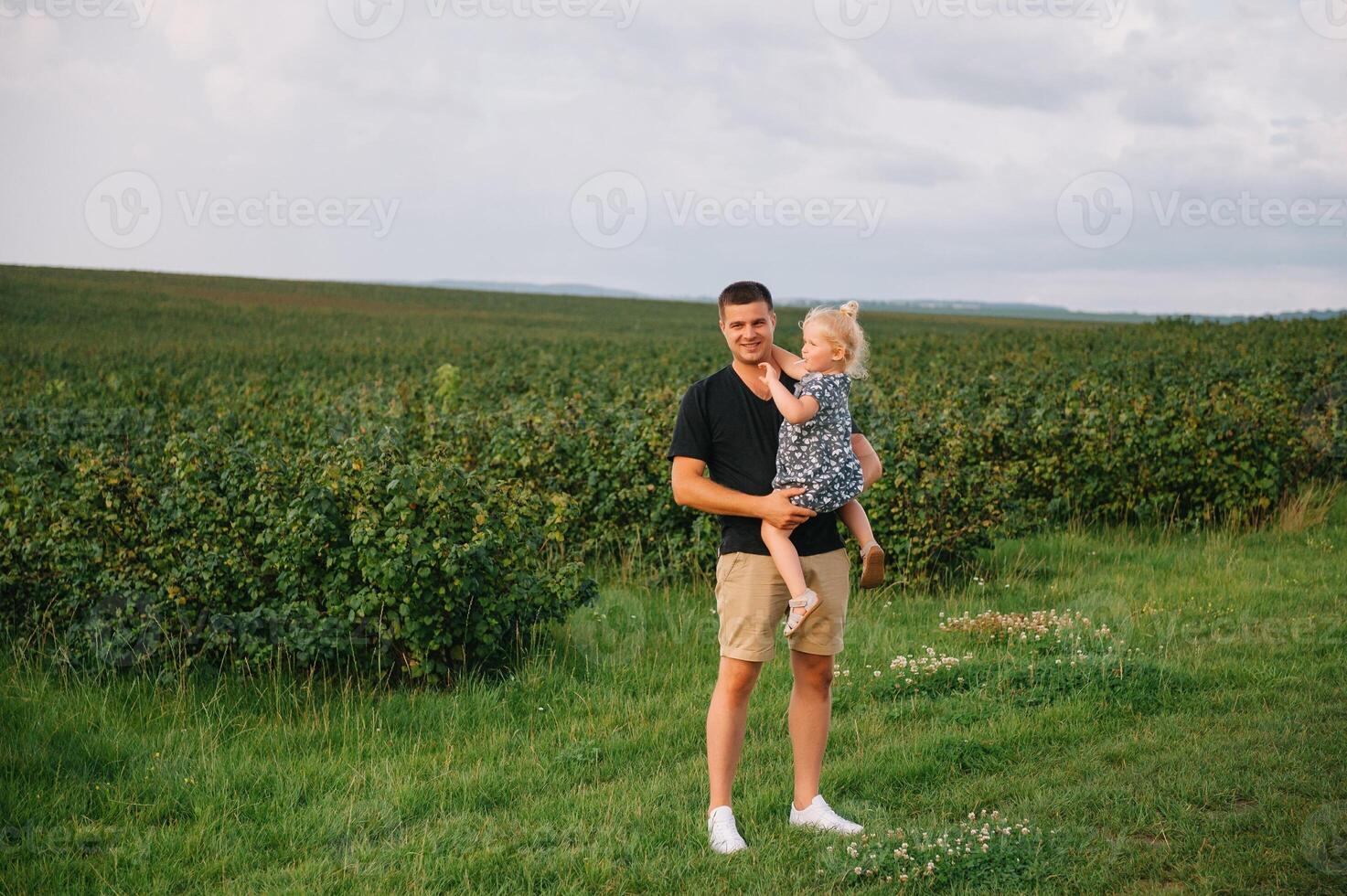 retrato de linda pequeño niña retenida en del padre brazos. contento amoroso familia. padre y su hija niño niña jugando abrazando linda bebé y papá. foto