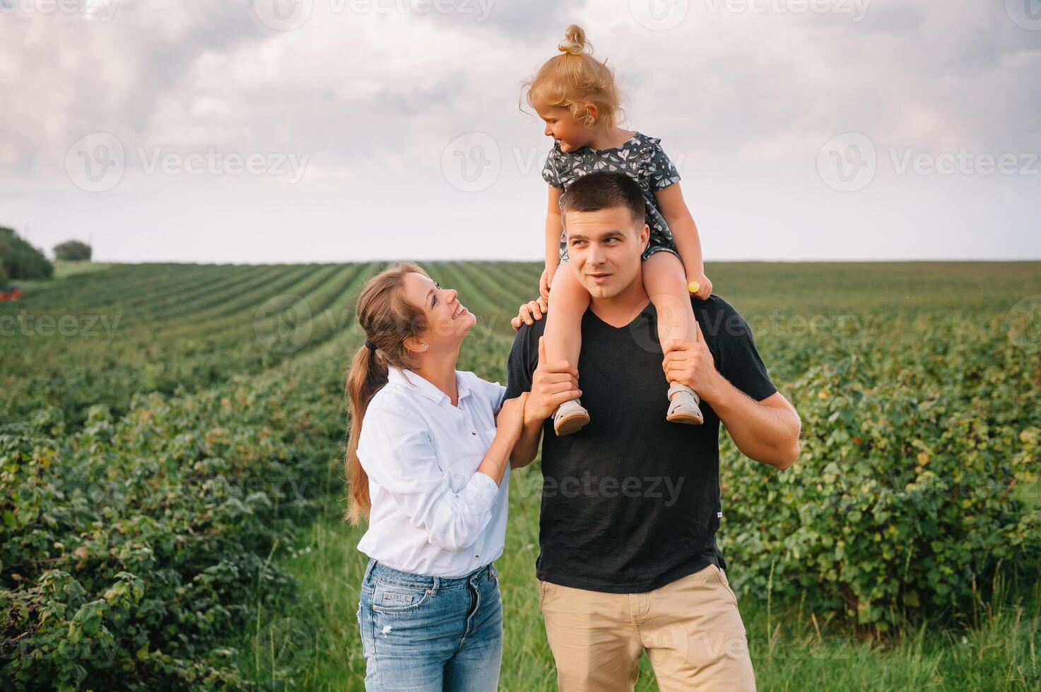 contento familia con pequeño hija gasto hora juntos en soleado campo. foto