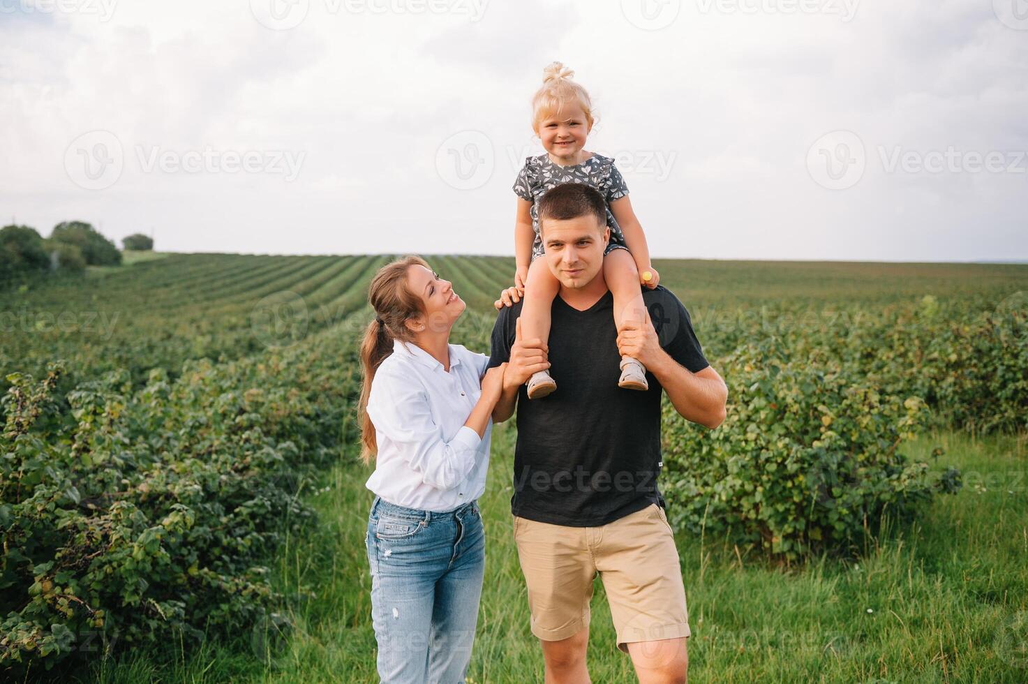 contento familia con pequeño hija gasto hora juntos en soleado campo. foto