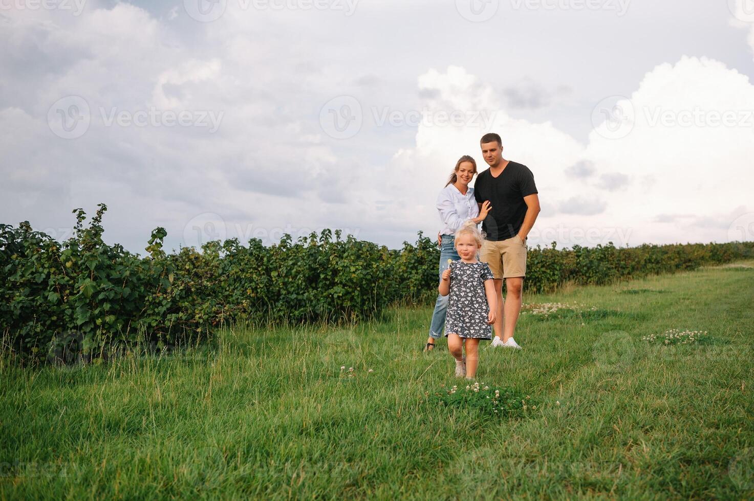 contento familia caminando en el parque. mamá, papá y hija caminar al aire libre, padres participación el bebé muchachas manos. infancia, paternidad, familia cautiverio, matrimonio concepto. foto