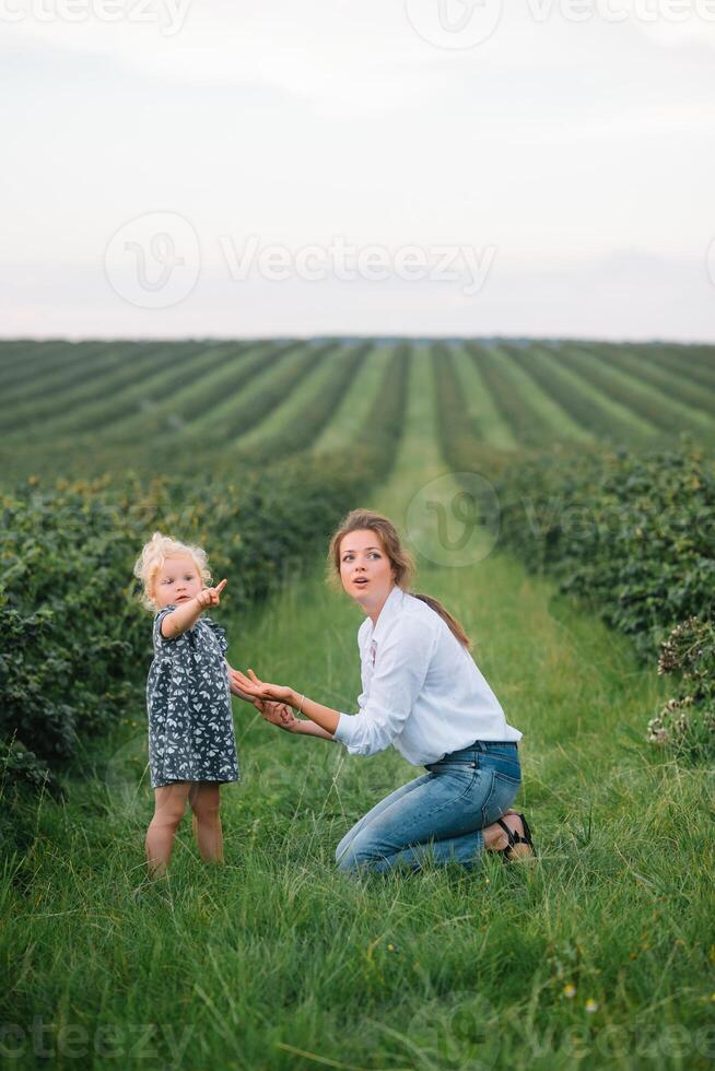 Stilish mother and daughter having fun on the nature. Happy family concept. Beauty nature scene with family outdoor lifestyle. Happy family resting together. Happiness in family life. Mothers day photo