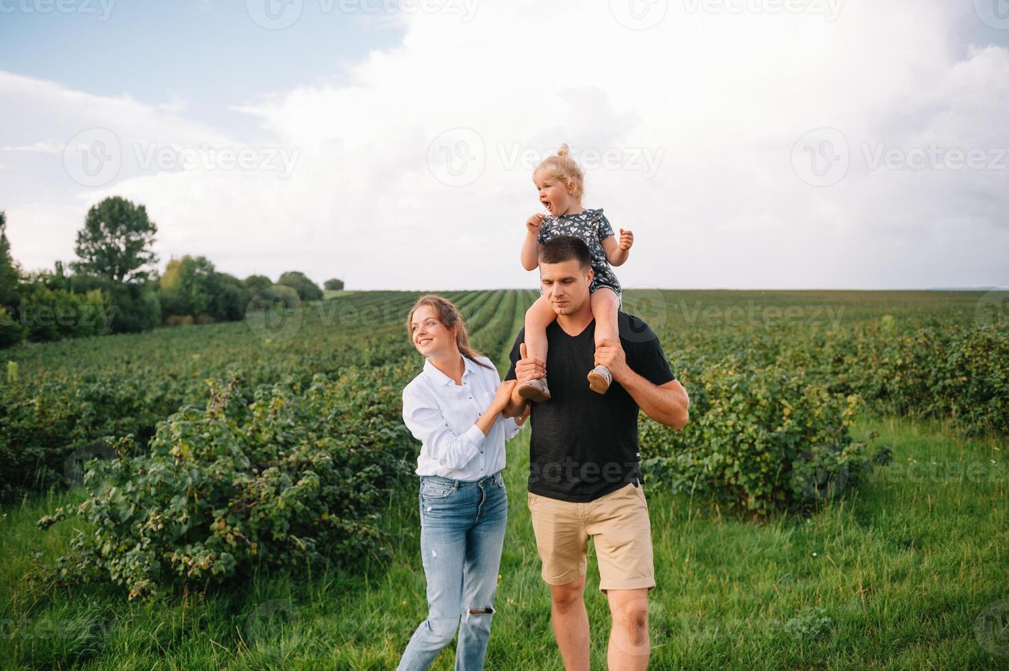 contento familia caminando en el parque. mamá, papá y hija caminar al aire libre, padres participación el bebé muchachas manos. infancia, paternidad, familia cautiverio, matrimonio concepto. foto