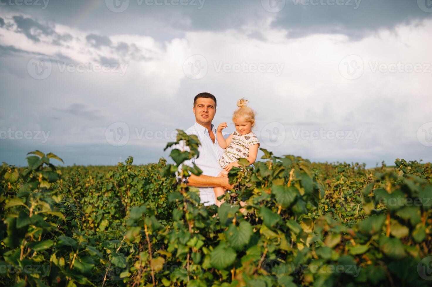 Portrait of cute little girl held in father's arms. Happy loving family. Father and his daughter child girl playing hugging. Cute baby and daddy. photo