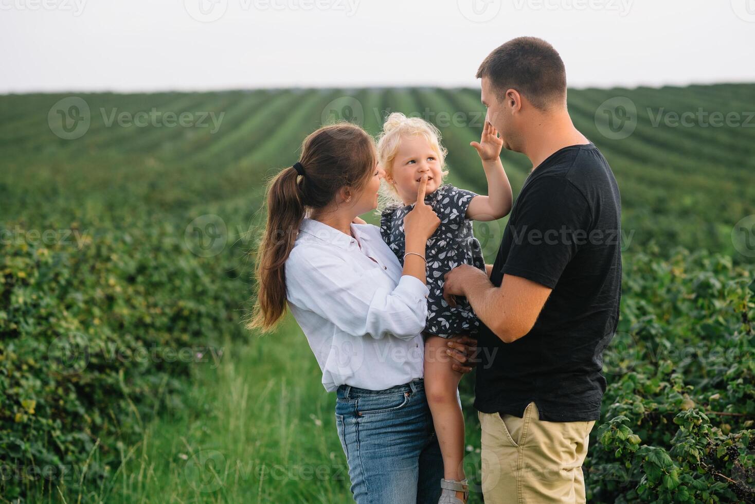 contento familia con pequeño hija gasto hora juntos en soleado campo. foto