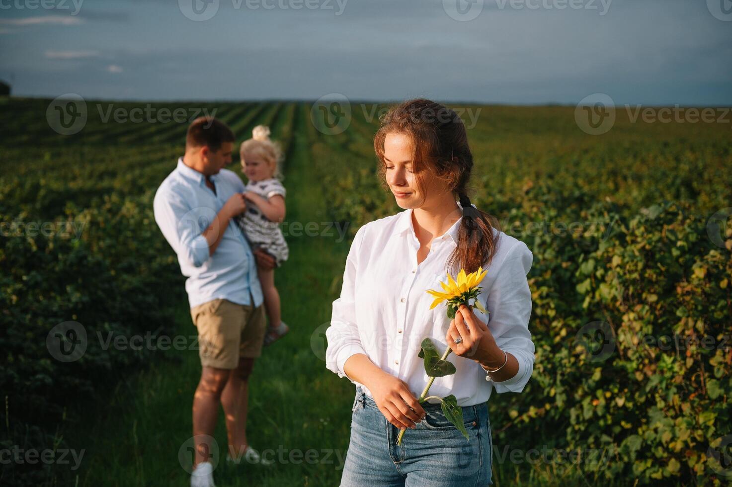 Happy family with little daughter spending time together in sunny field. photo