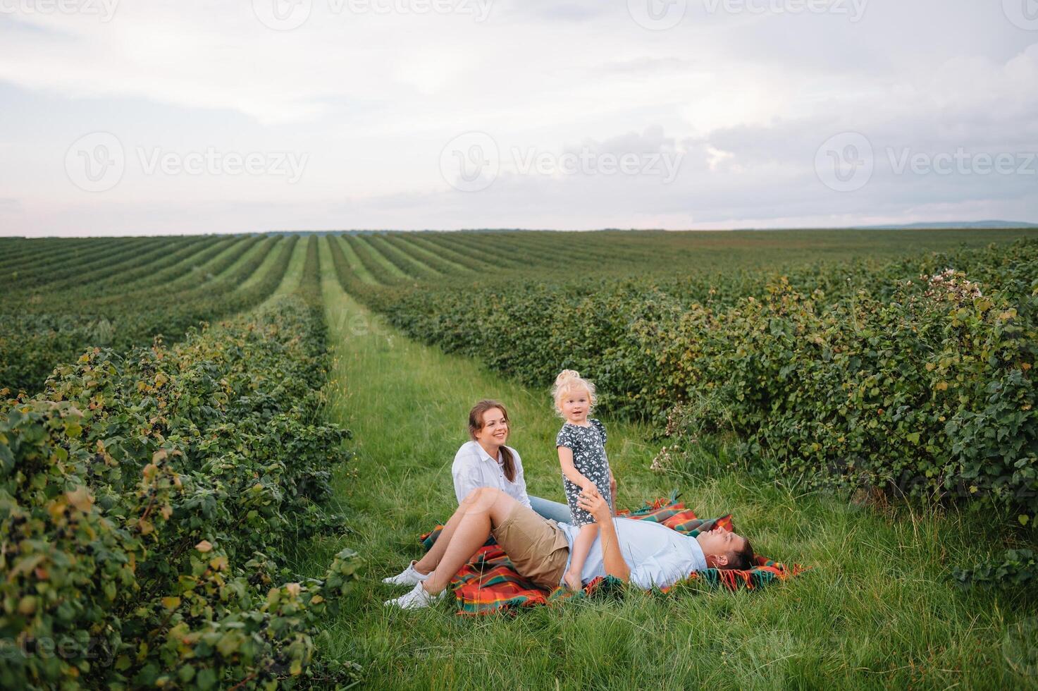 contento familia con pequeño hija gasto hora juntos en soleado campo. foto