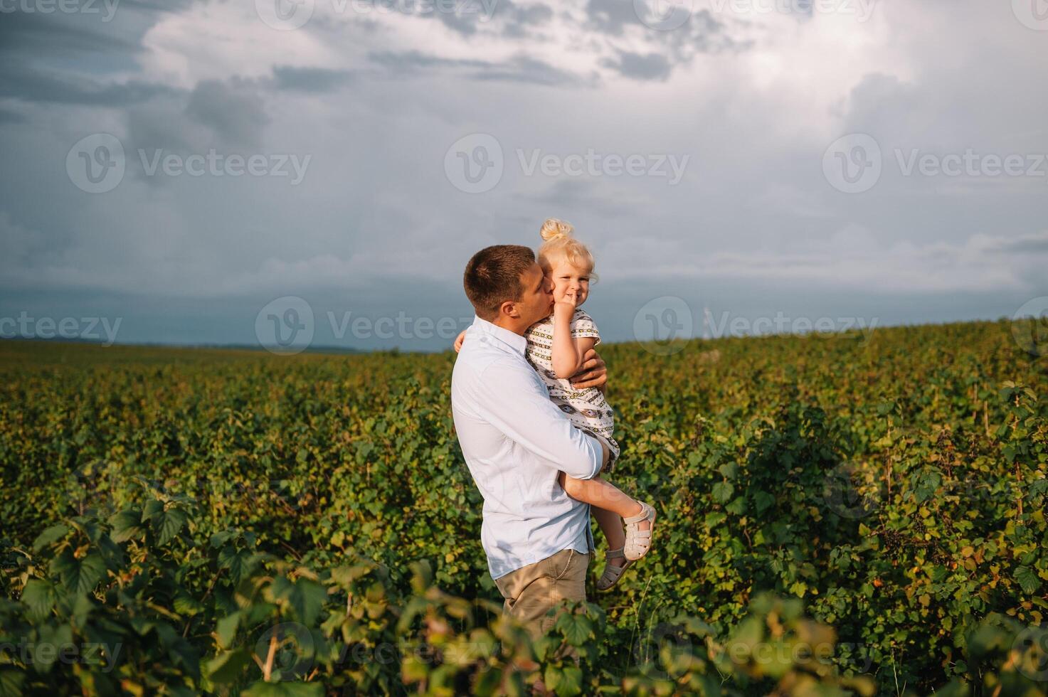 retrato de linda pequeño niña retenida en del padre brazos. contento amoroso familia. padre y su hija niño niña jugando abrazando linda bebé y papá. foto