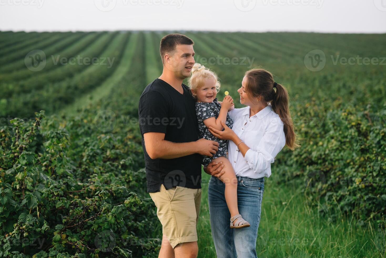 contento familia caminando en el parque. mamá, papá y hija caminar al aire libre, padres participación el bebé muchachas manos. infancia, paternidad, familia cautiverio, matrimonio concepto. foto