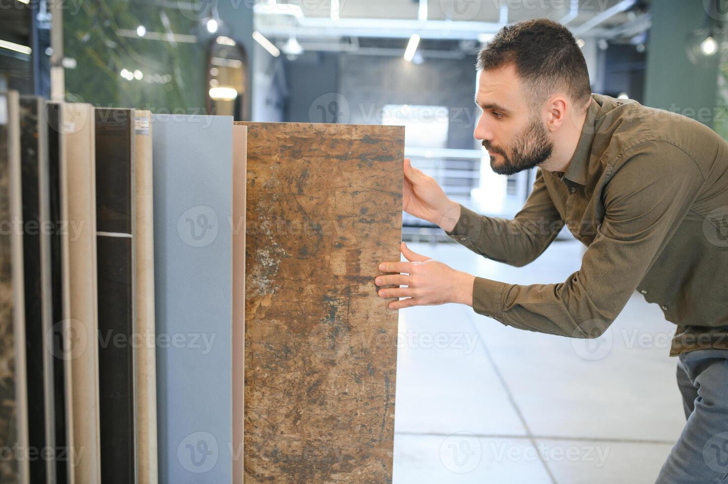 Male customer choosing kitchen ceramic tile in store photo