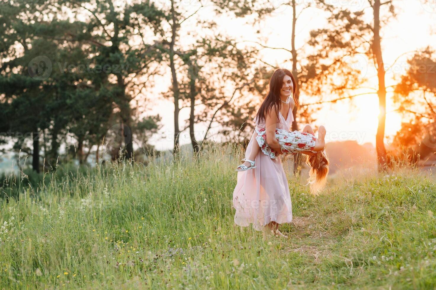 elegante madre y hermoso hija teniendo divertido en el naturaleza. contento familia concepto. belleza naturaleza escena con familia al aire libre estilo de vida. familia descansando juntos. felicidad en familia vida. madres día. foto