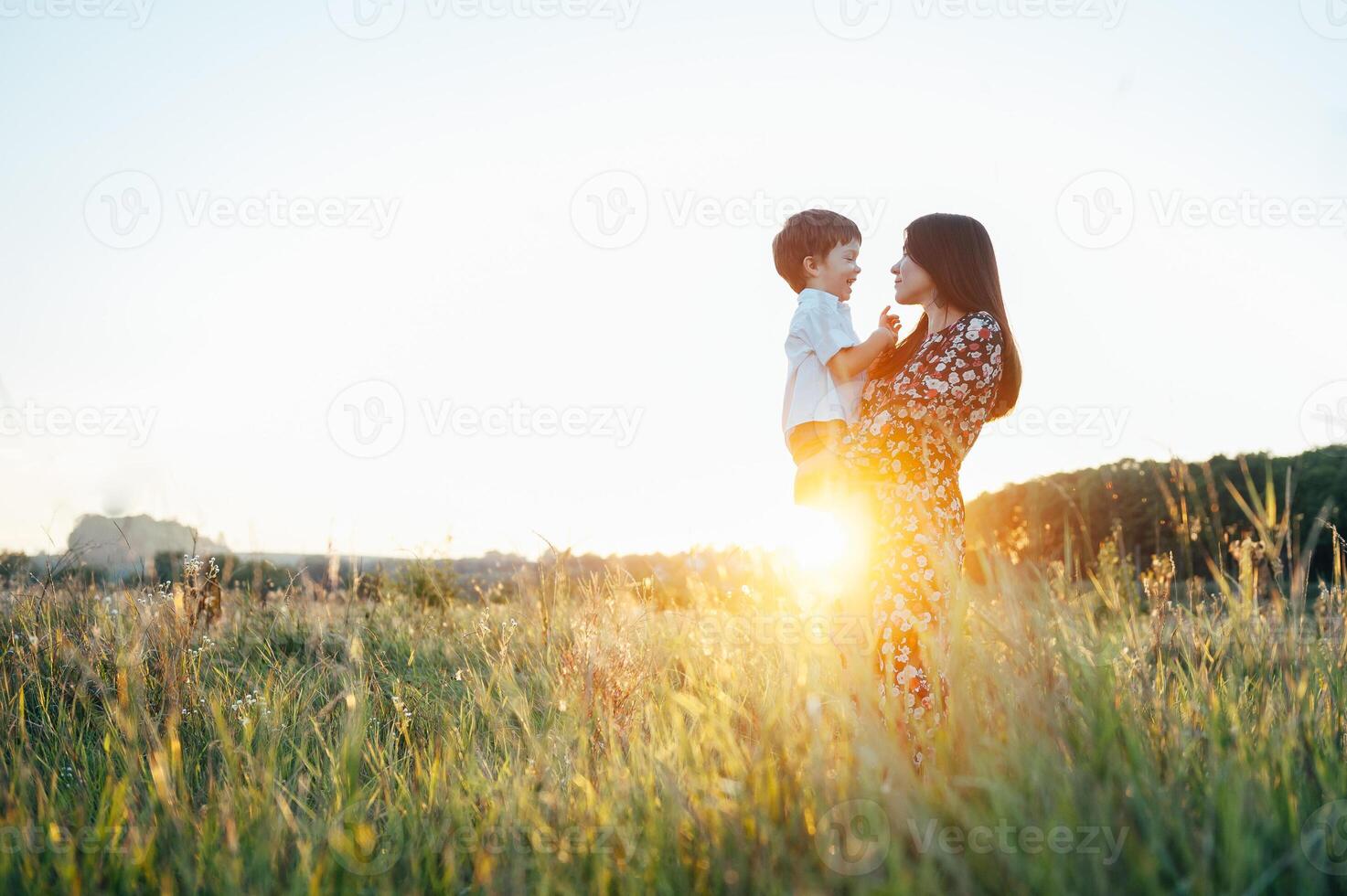 elegante madre y hermoso hijo teniendo divertido en el naturaleza. contento familia concepto. belleza naturaleza escena con familia al aire libre estilo de vida. contento familia descansando juntos. felicidad en familia vida. madres día foto