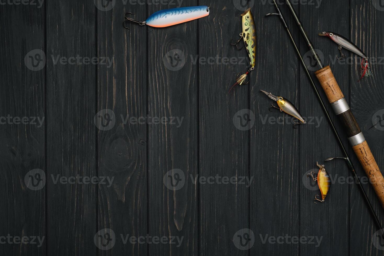 Fishing tackle - fishing spinning, hooks and lures on darken wooden background. Top view photo