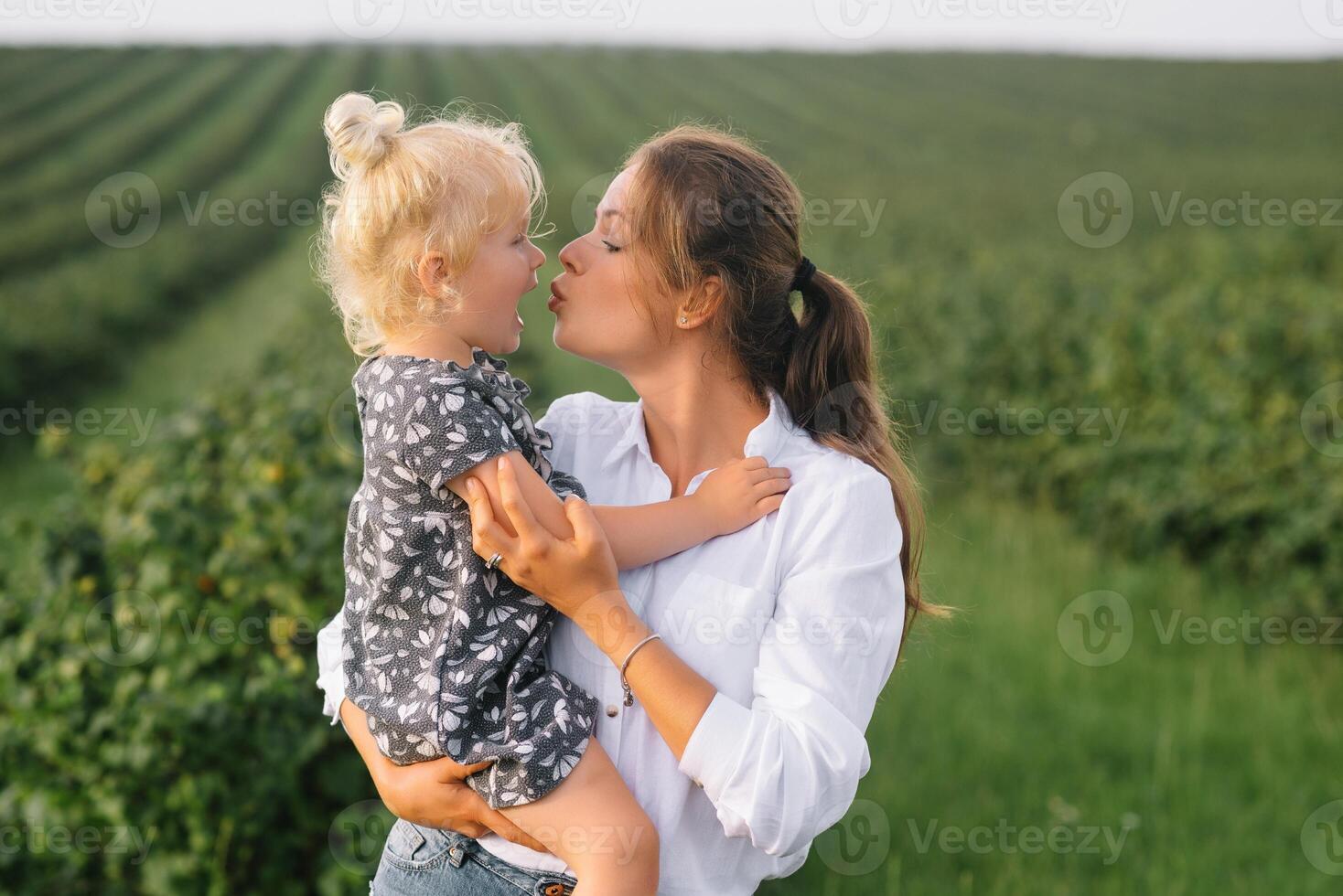 Stilish mother and daughter having fun on the nature. Happy family concept. Beauty nature scene with family outdoor lifestyle. Happy family resting together. Happiness in family life. Mothers day photo