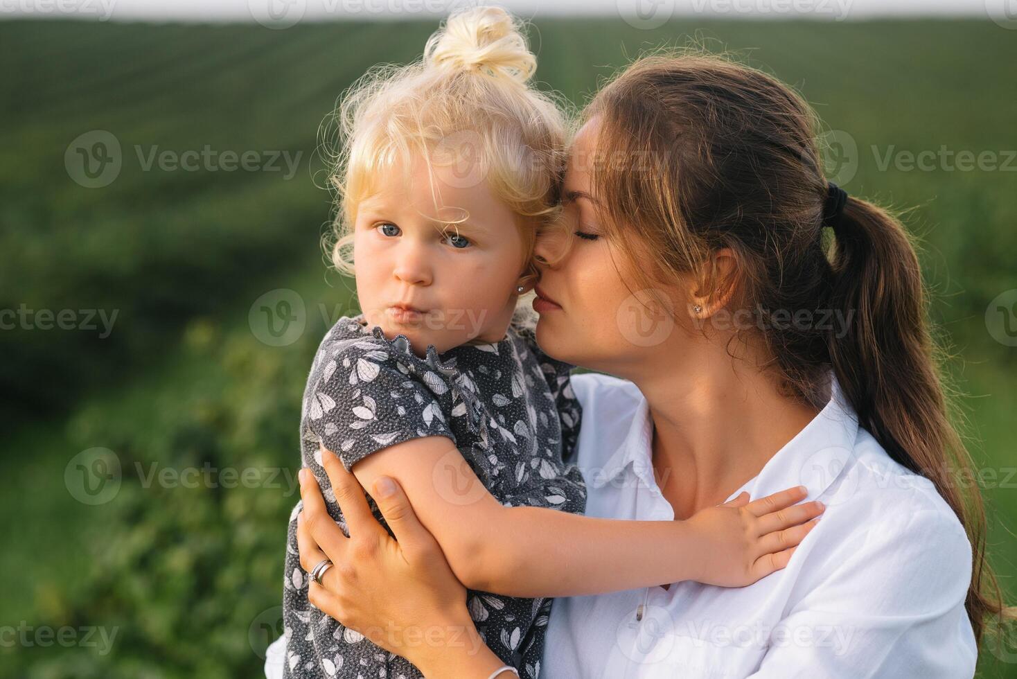 elegante madre y hija teniendo divertido en el naturaleza. contento familia concepto. belleza naturaleza escena con familia al aire libre estilo de vida. contento familia descansando juntos. felicidad en familia vida. madres día foto