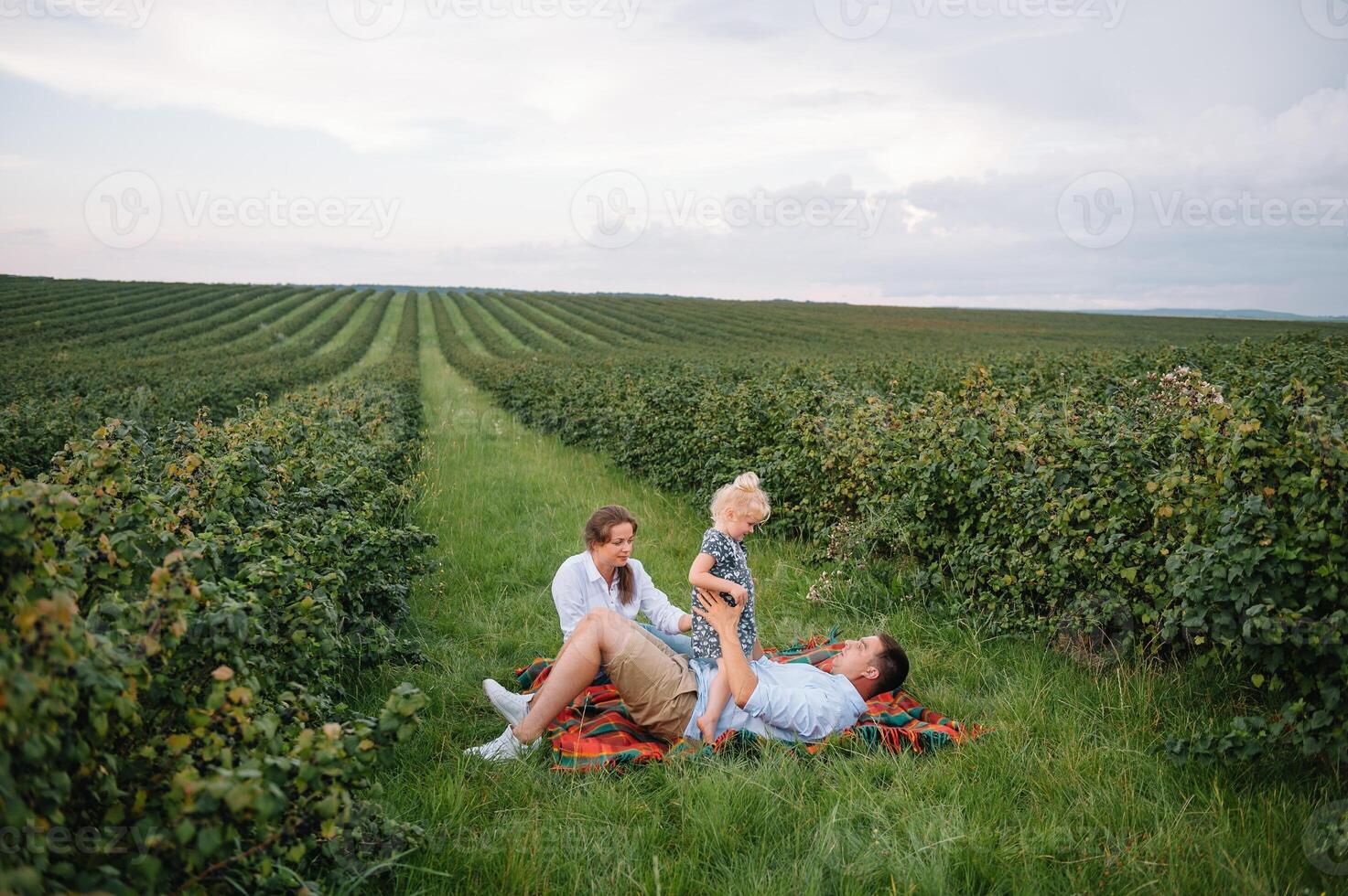 contento familia con pequeño hija gasto hora juntos en soleado campo. foto