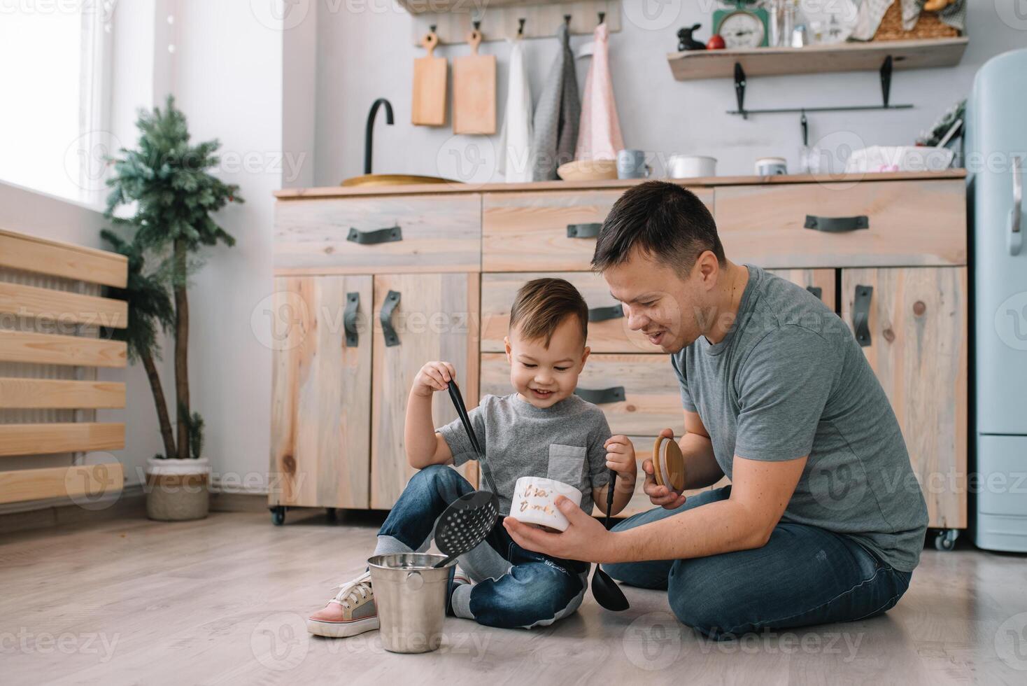 Young man and his son with oven sheet in kitchen. Father with little son on the kitchen photo