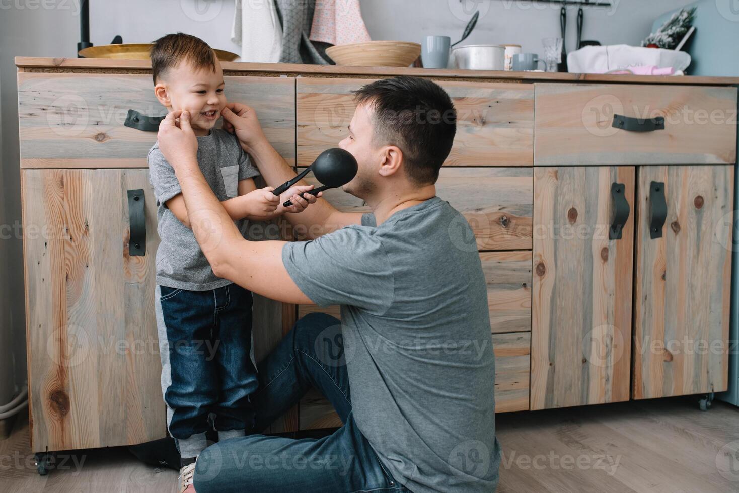 Young man and his son with oven sheet in kitchen. Father with little son on the kitchen photo