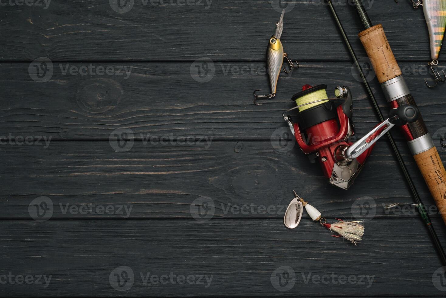 Fishing tackle - fishing spinning, hooks and lures on darken wooden background. Top view photo