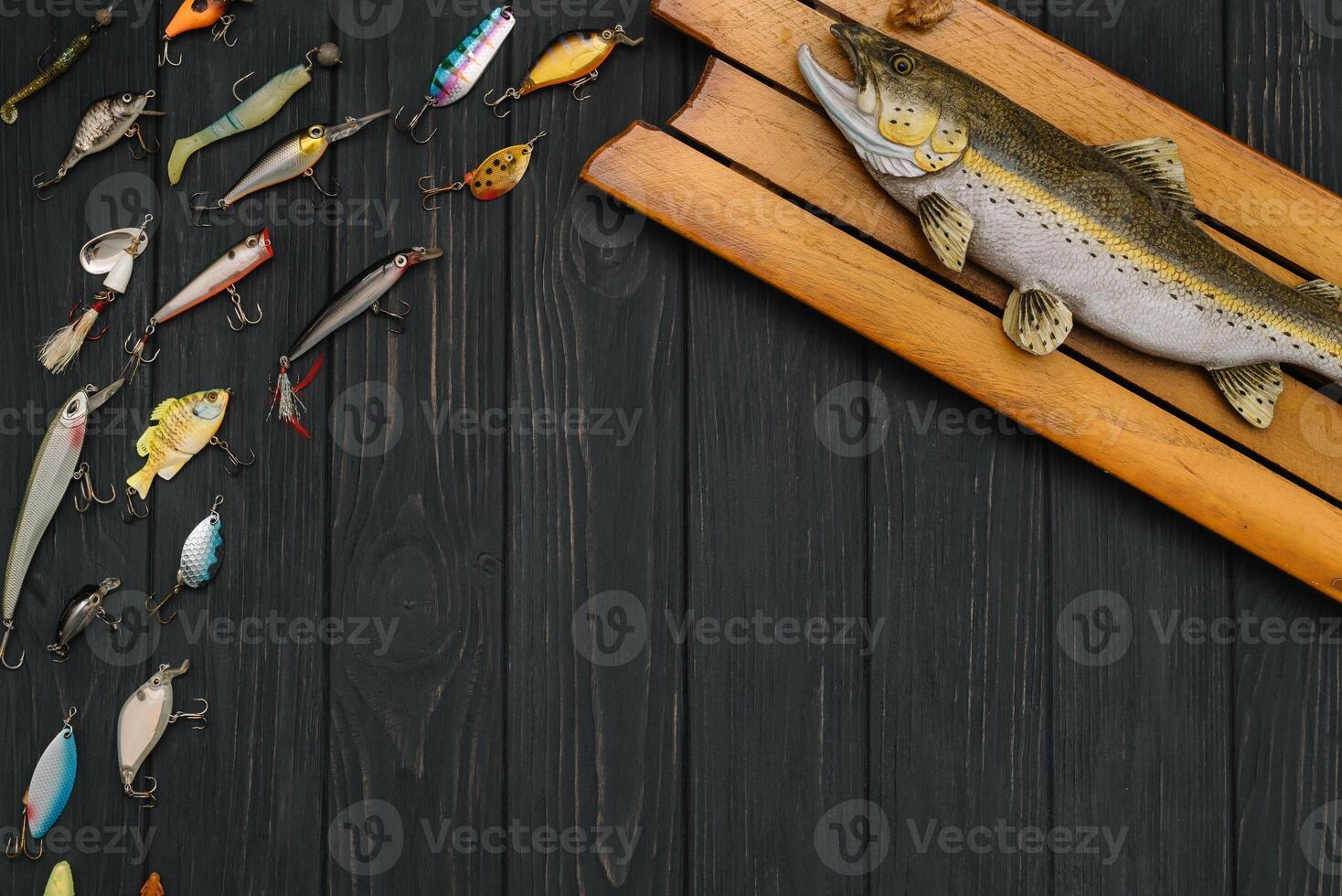 Fishing tackle - fishing spinning, hooks and lures on darken wooden background. Top view photo