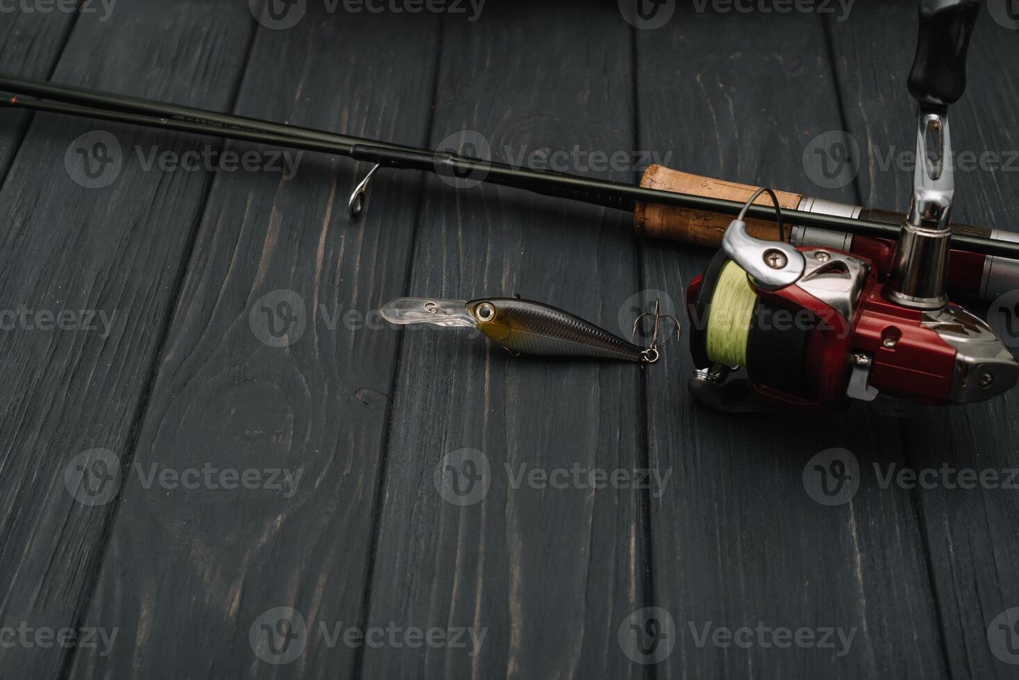 Fishing tackle - fishing spinning, hooks and lures on darken wooden background. Top view photo