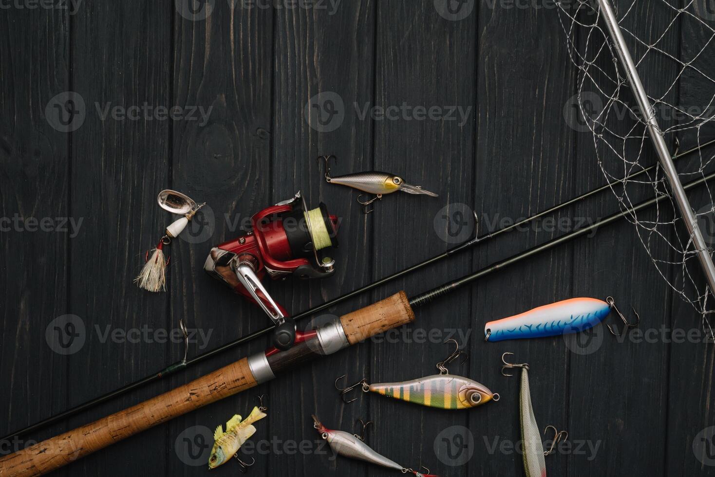 Fishing tackle - fishing spinning, hooks and lures on darken wooden background. Top view photo