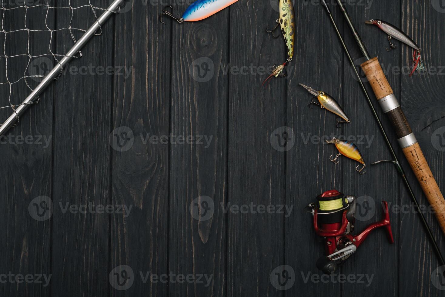 Fishing tackle - fishing spinning, hooks and lures on darken wooden background. Top view photo