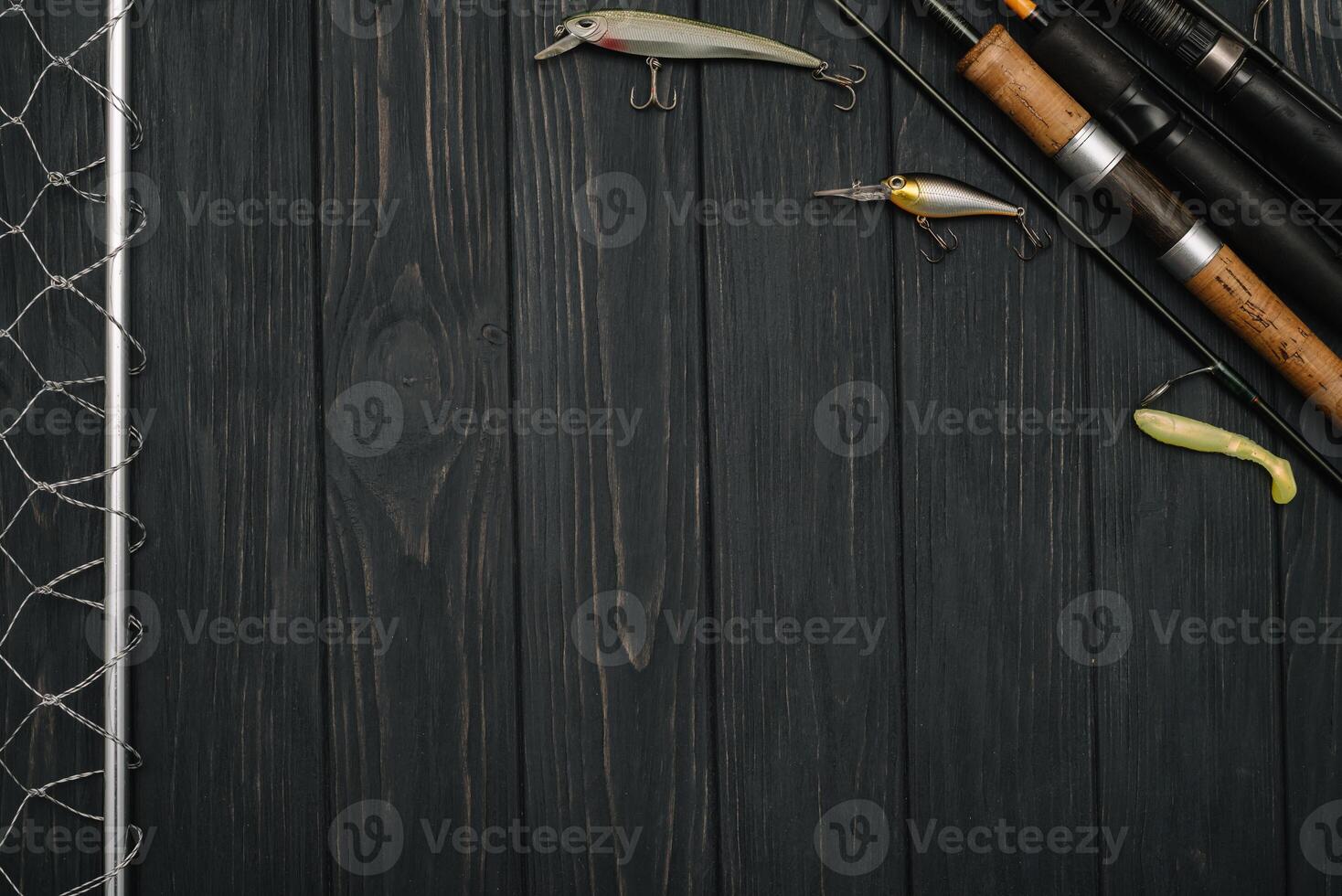 Fishing tackle - fishing spinning, hooks and lures on darken wooden background. Top view photo