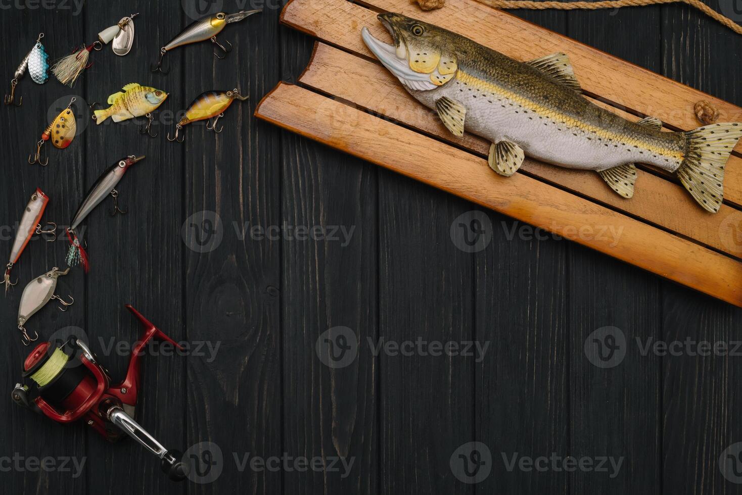 Fishing tackle - fishing spinning, hooks and lures on darken wooden background. Top view photo